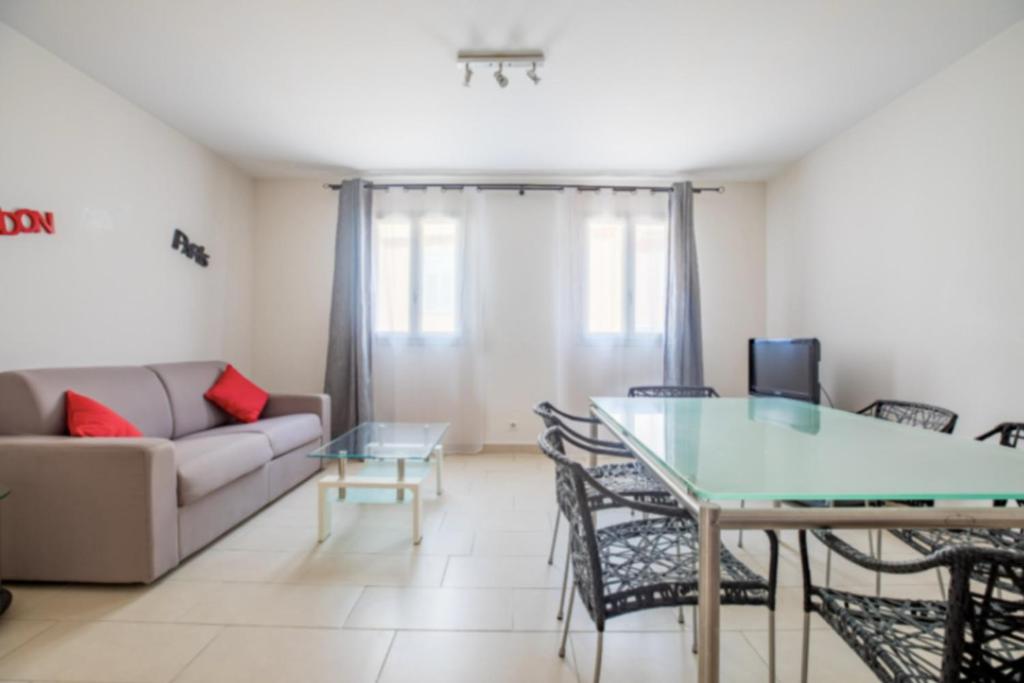 un salon avec une table et un canapé dans l'établissement Bright Apartment In The Heart Of Cannes, à Cannes
