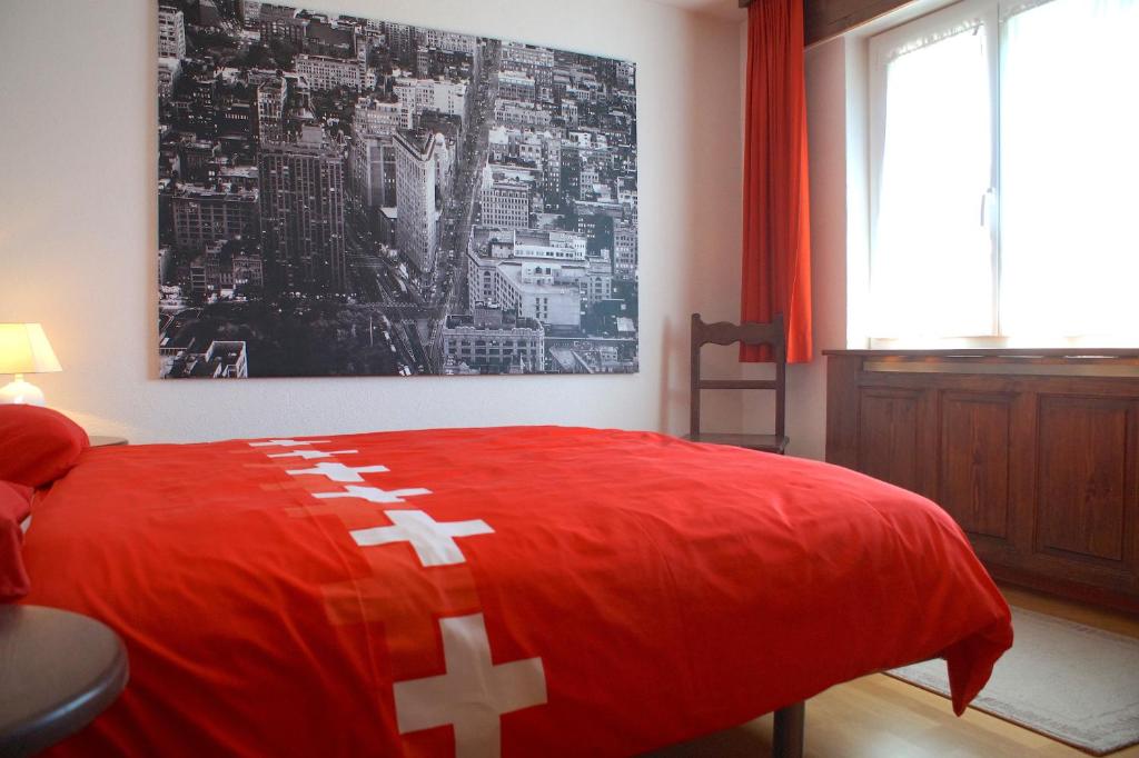Un dormitorio con una cama roja con cruces blancas. en Central for up to 7 guests, Flaminia, en Crans-Montana