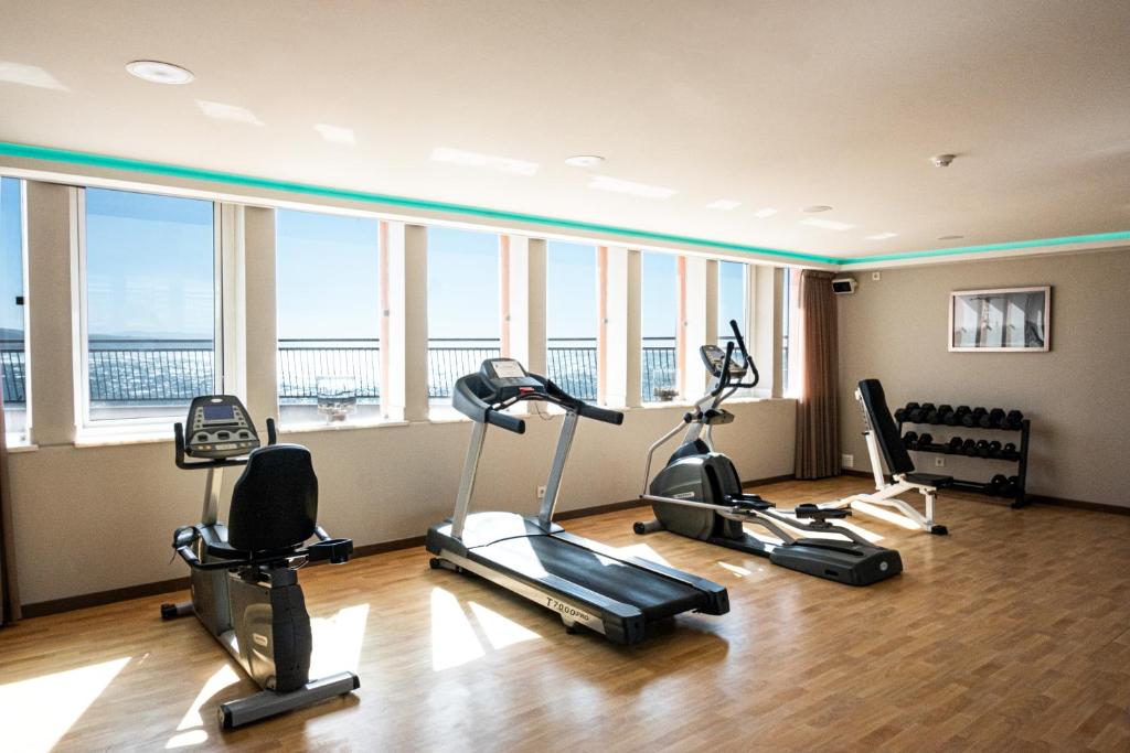 a gym with several exercise bikes in a room with windows at Vila Gale Ericeira in Ericeira