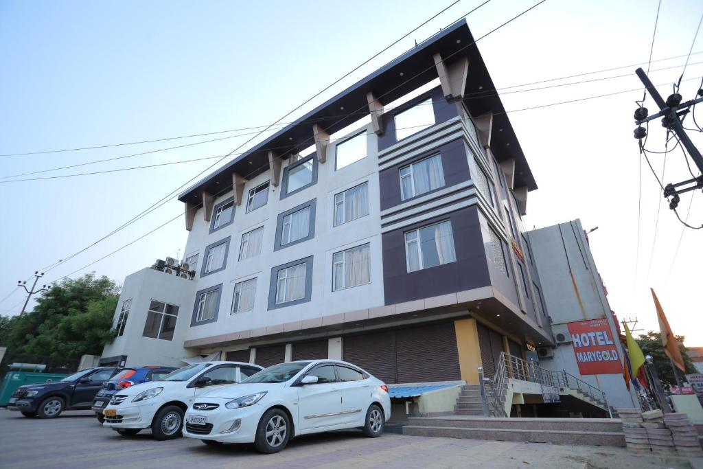 a building with cars parked in front of it at Hotel Marygold in Agra