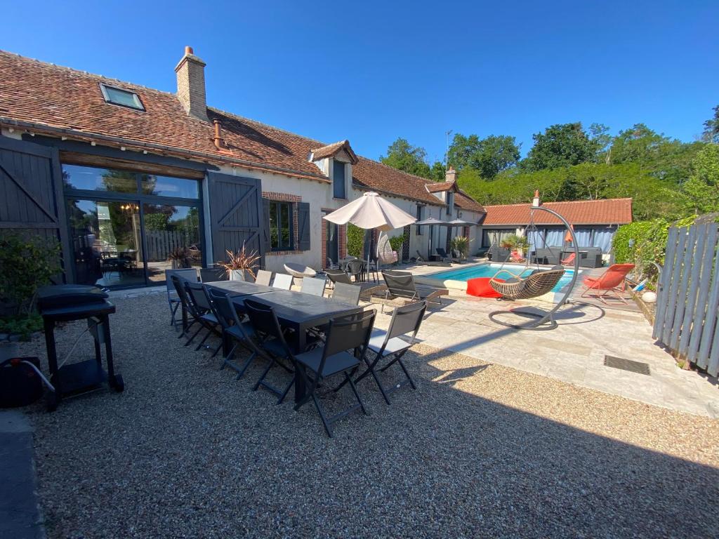 a patio with a table and chairs and a pool at Le Val de Nodicia in Montlivault