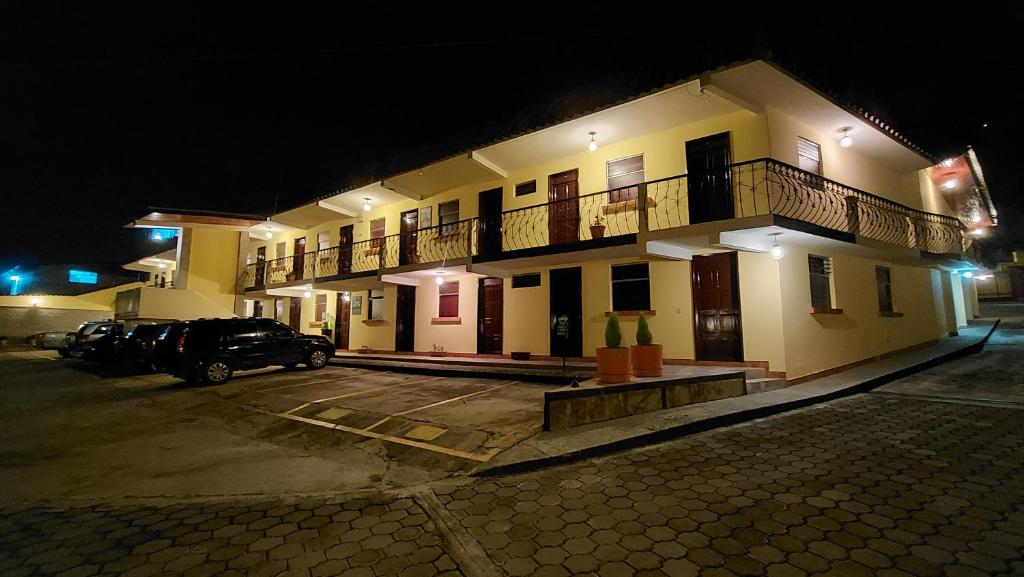 um parque de estacionamento em frente a um edifício à noite em Hotel y Restaurante Villa Esmeralda em Quetzaltenango