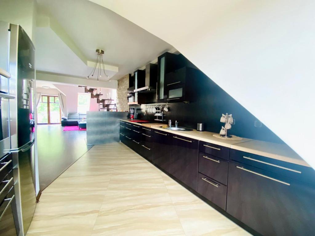 a kitchen with black cabinets and a long floor at Apartament in Szczytno