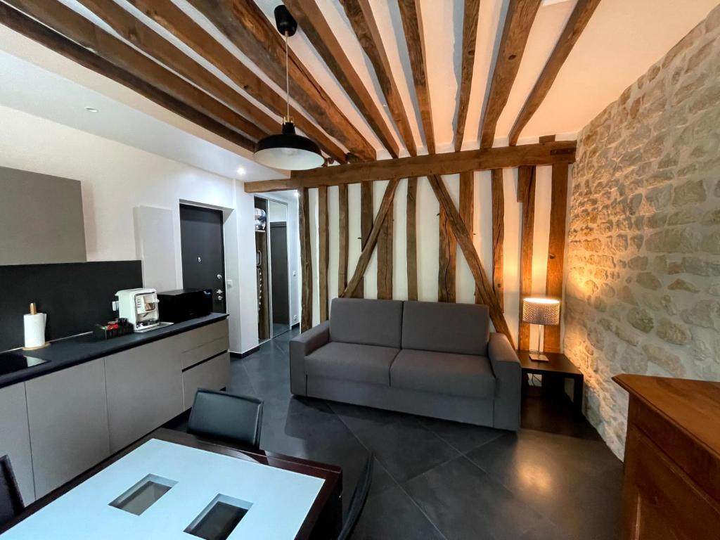 een woonkamer met een bank en een bakstenen muur bij Thegreatflat in Parijs