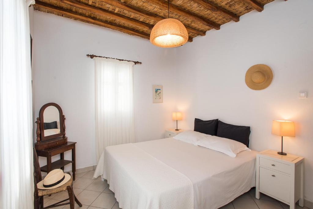 biała sypialnia z białym łóżkiem i lustrem w obiekcie Charming House Platy Gialos w mieście Platis Gialos Mykonos