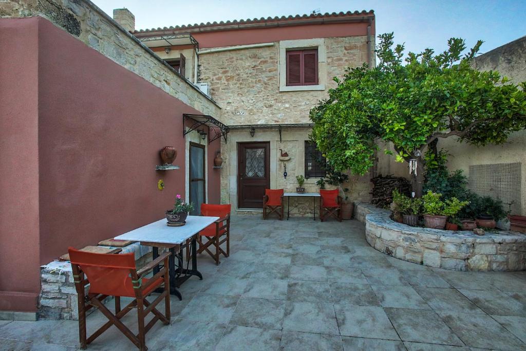 a patio with a table and chairs in front of a house at Cretan Traditional Home in Tílisos