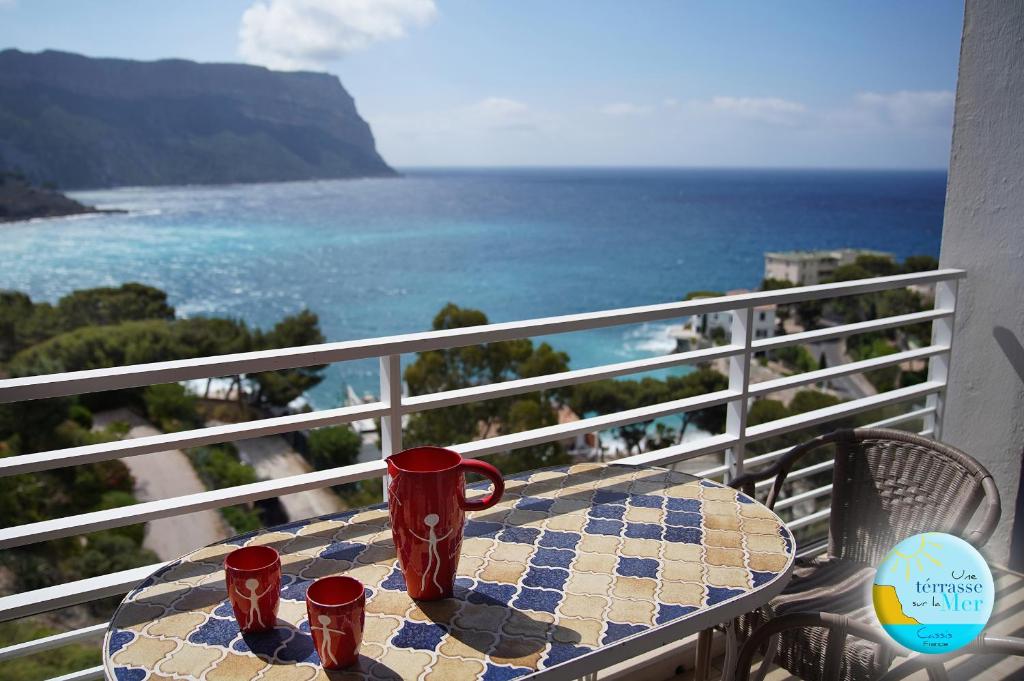 a table on a balcony with a view of the ocean at UNE TERRASSE SUR LA MER 3 pers 2 chambres VUE MER in Cassis