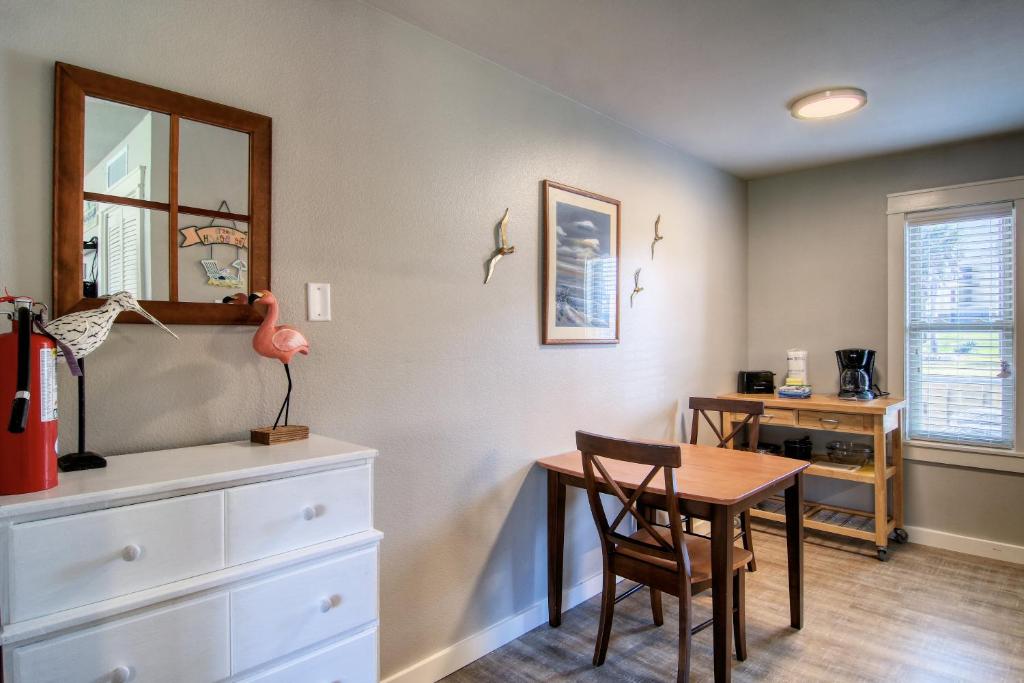 a dining room with a table and a desk at Courtyard #113 in Port Aransas