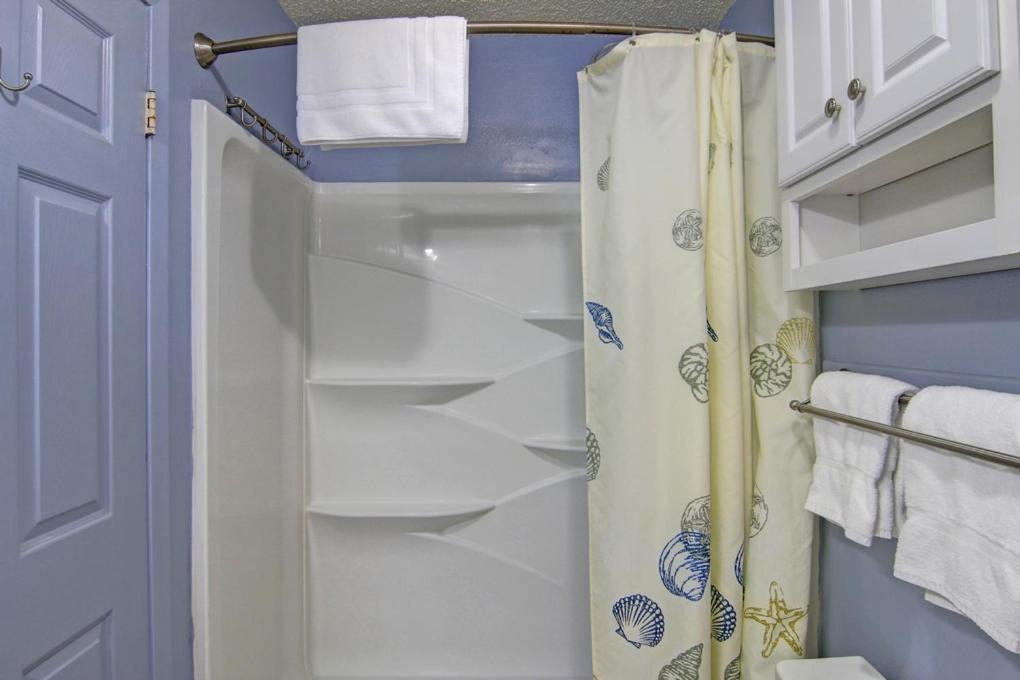 a bathroom with a shower curtain and a toilet at Courtyard #206 in Port Aransas