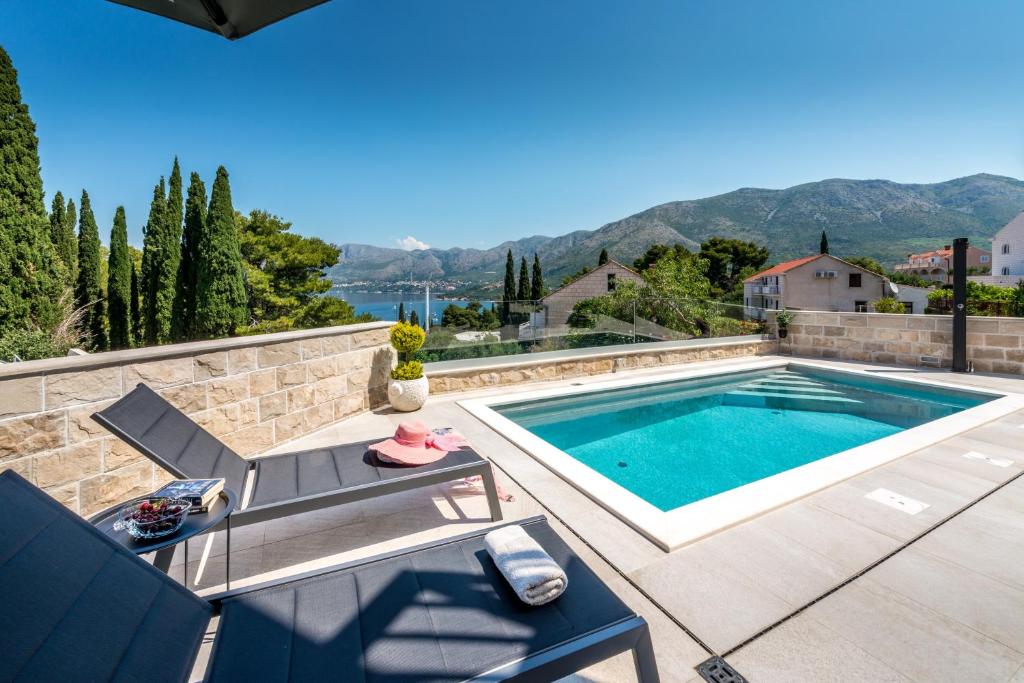 a swimming pool in the backyard of a house at Apartments Aldo in Cavtat