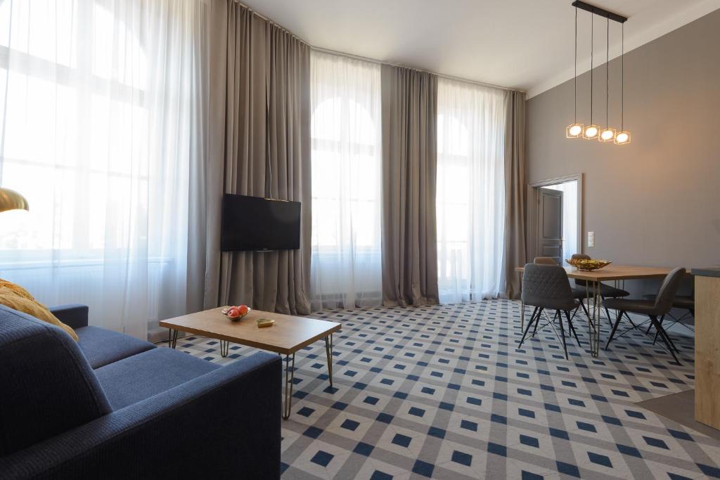 KH Opera Apartments في فيينا: غرفة معيشة مع أريكة زرقاء وطاولة