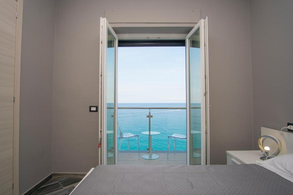 una camera con letto e vista sull'oceano di La Dimora sul Mare a Marina di Camerota