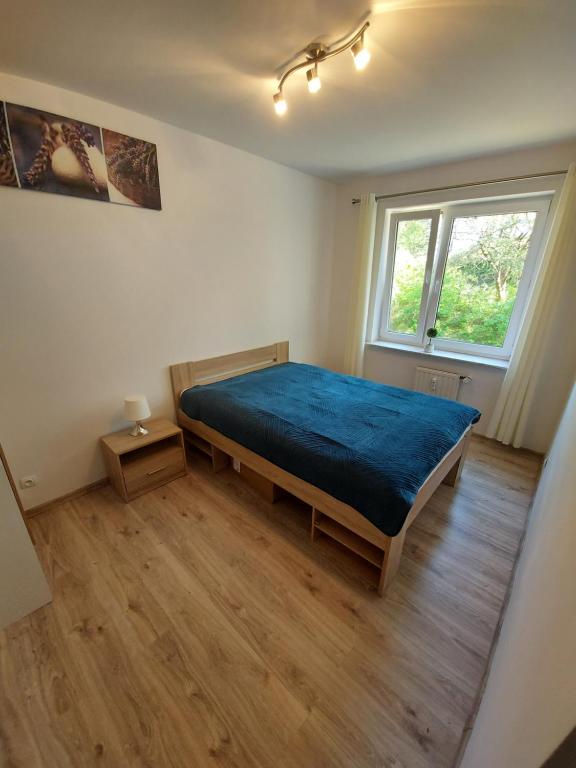 ein Schlafzimmer mit einem großen Bett mit einer blauen Decke in der Unterkunft Apartament z widokiem na las Na wydmie in Ustka