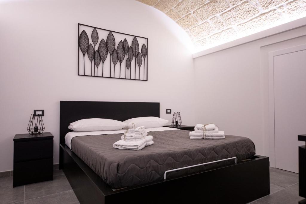 a bedroom with a bed with two towels on it at Amare Cefalù - Elegant Apartment in Cefalù