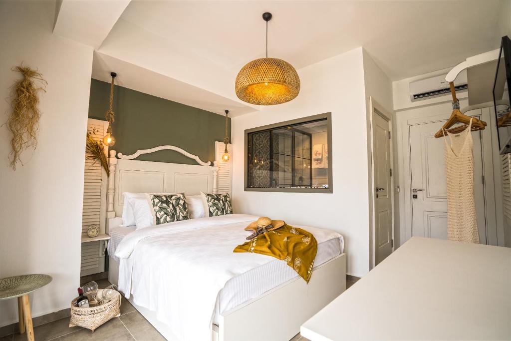 a bedroom with a white bed with a gold blanket on it at Liman Hotel Gümüslük - Adult Only in Bodrum City