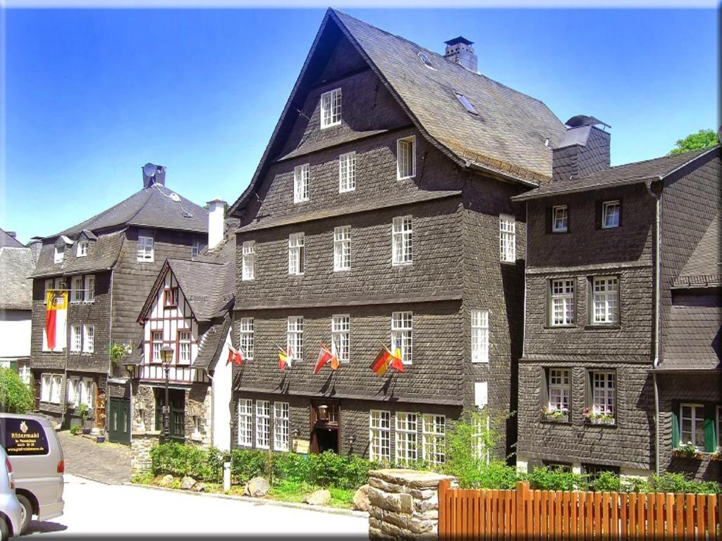 a large building with red bows in front of it at Hotel Graf Rolshausen in Monschau