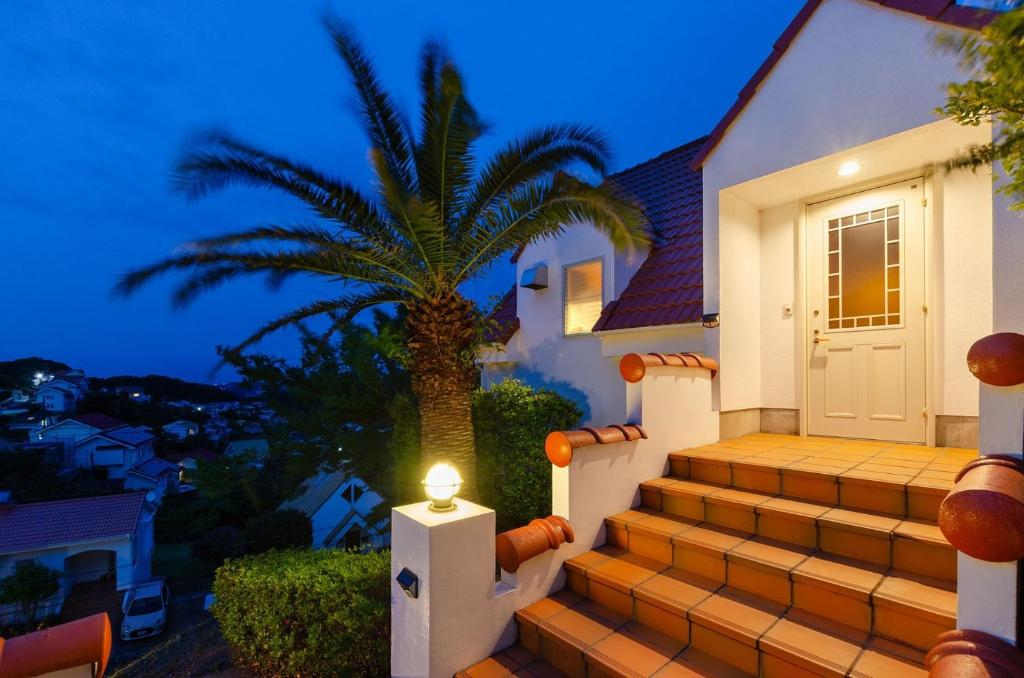 下田的住宿－Bay Coast Villa Goishigahama - Vacation STAY 45736v，一座棕榈树的房子,楼梯上有一盏灯