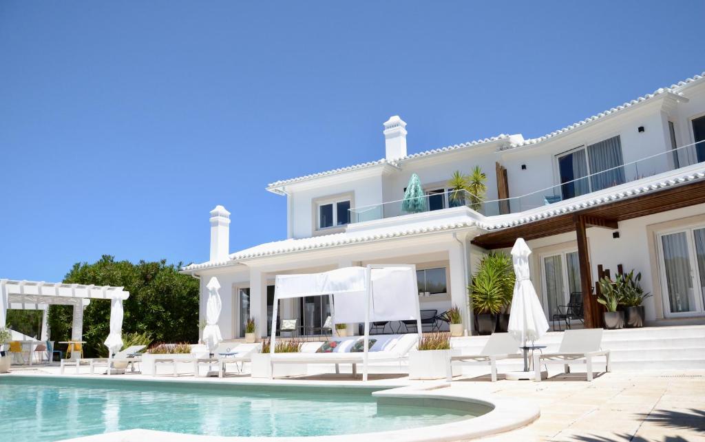 une villa avec une piscine et une maison dans l'établissement EMCASA Boutique Guesthouse, à Lourinhã