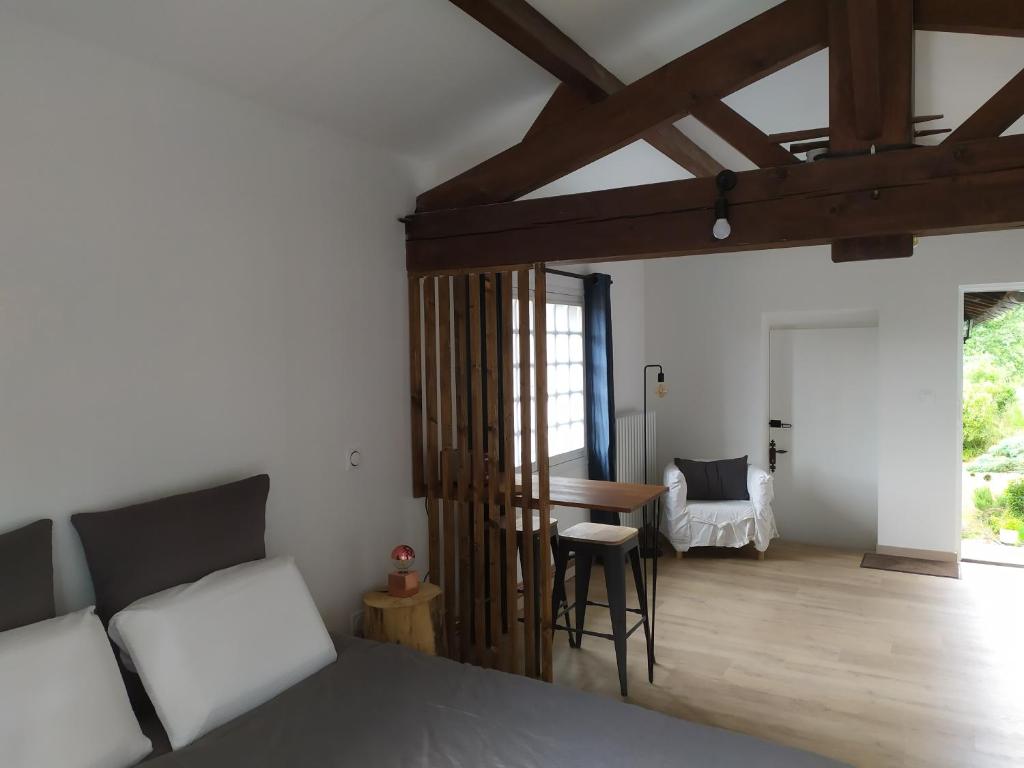 1 dormitorio con 1 cama y 1 mesa en una habitación en Les gîtes des Beaux Chênes, en Mortagne-sur-Sèvre