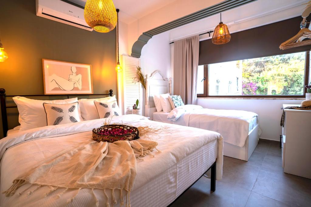 a bedroom with two beds and a large window at Liman Hotel Gümüslük - Adult Only in Bodrum City