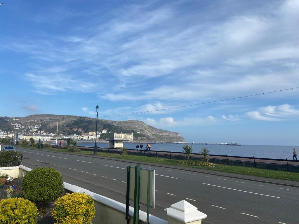 eine Straße mit Blick auf den Strand und das Meer in der Unterkunft The Shelbourne in Llandudno