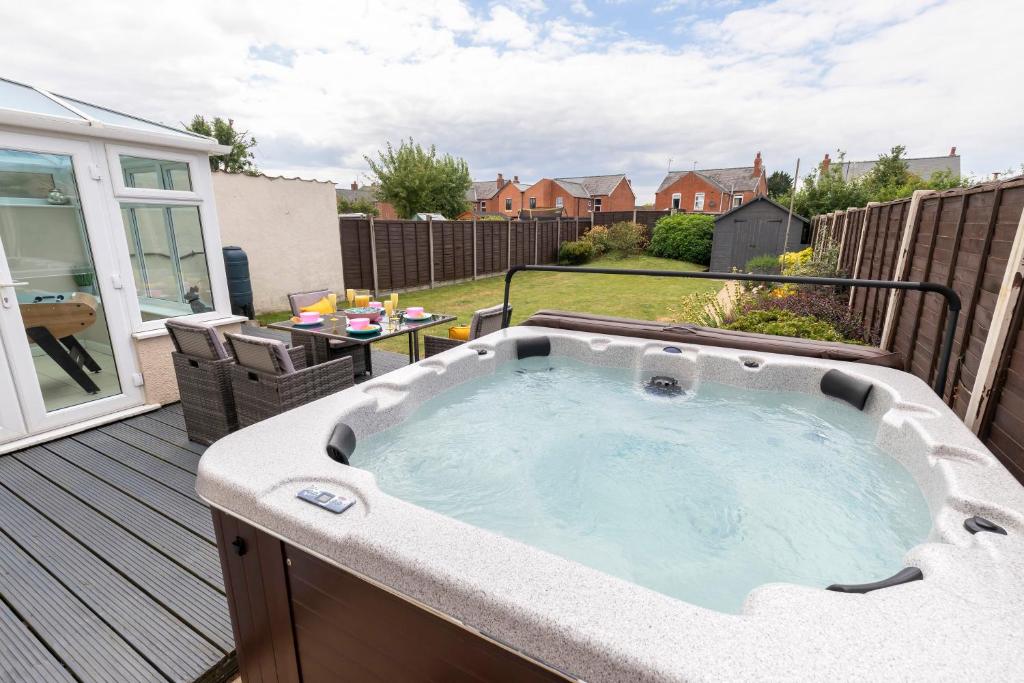 bañera de hidromasaje en la terraza de un patio trasero en Modern Three Bedroom Home in Gloucester with Hot Tub, en Gloucester