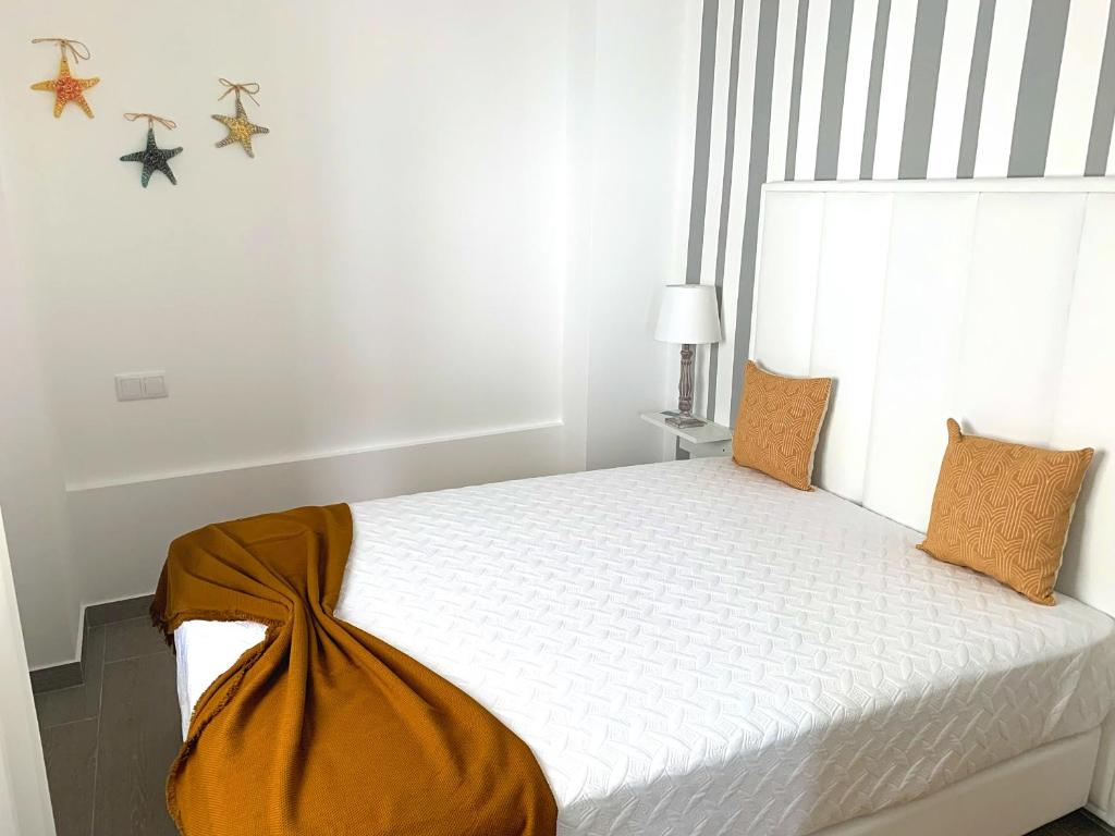 una camera da letto con un letto bianco con una grande finestra di Duarte Houses - Casa T1 N - com vista mar a Nazaré