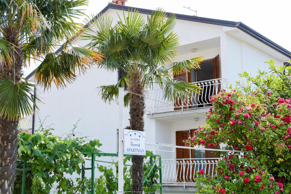 una casa blanca con palmeras delante en Villa Vienna en Novigrad Istria