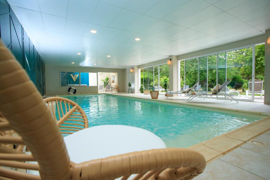 uma piscina com uma cadeira e uma mesa e cadeiras em VILLA VARENTIA em Villers-Bretonneux