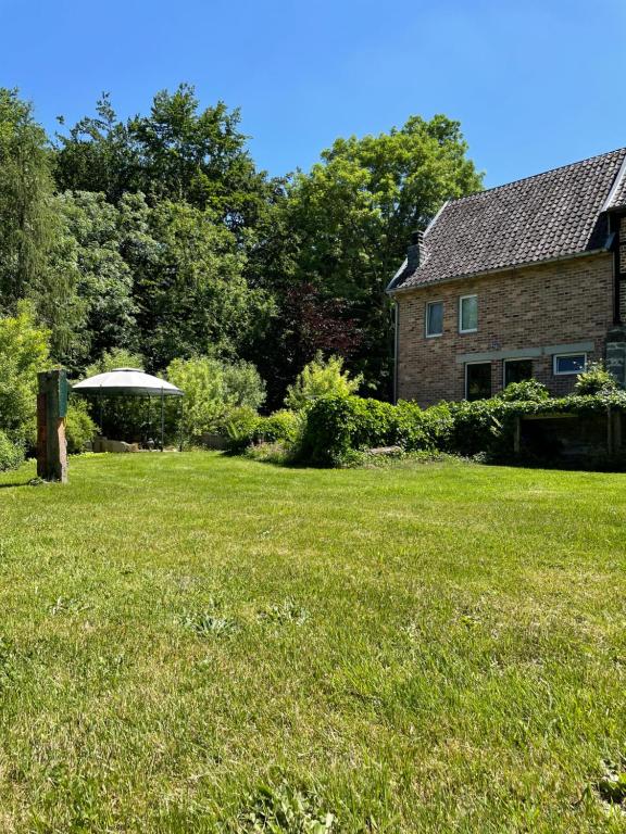 um quintal com uma casa e um campo de relva em Bellevue Maison de Greunebennet em Plombières