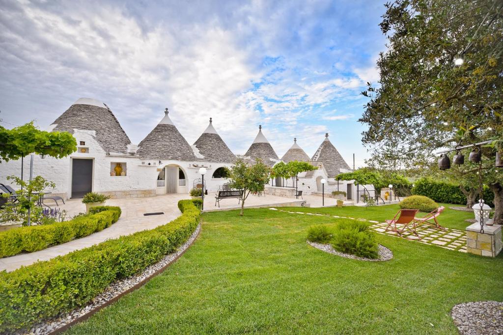 ein Haus mit einem Garten mit einem Rasenplatz in der Unterkunft B&B Masseria Nuove Caselle in Villa Castelli