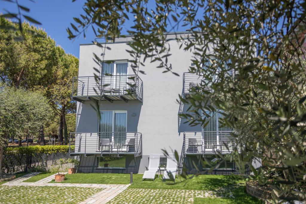 a white building with balconies and a yard at INSULA FELIX Bed&Breakfast in Moniga