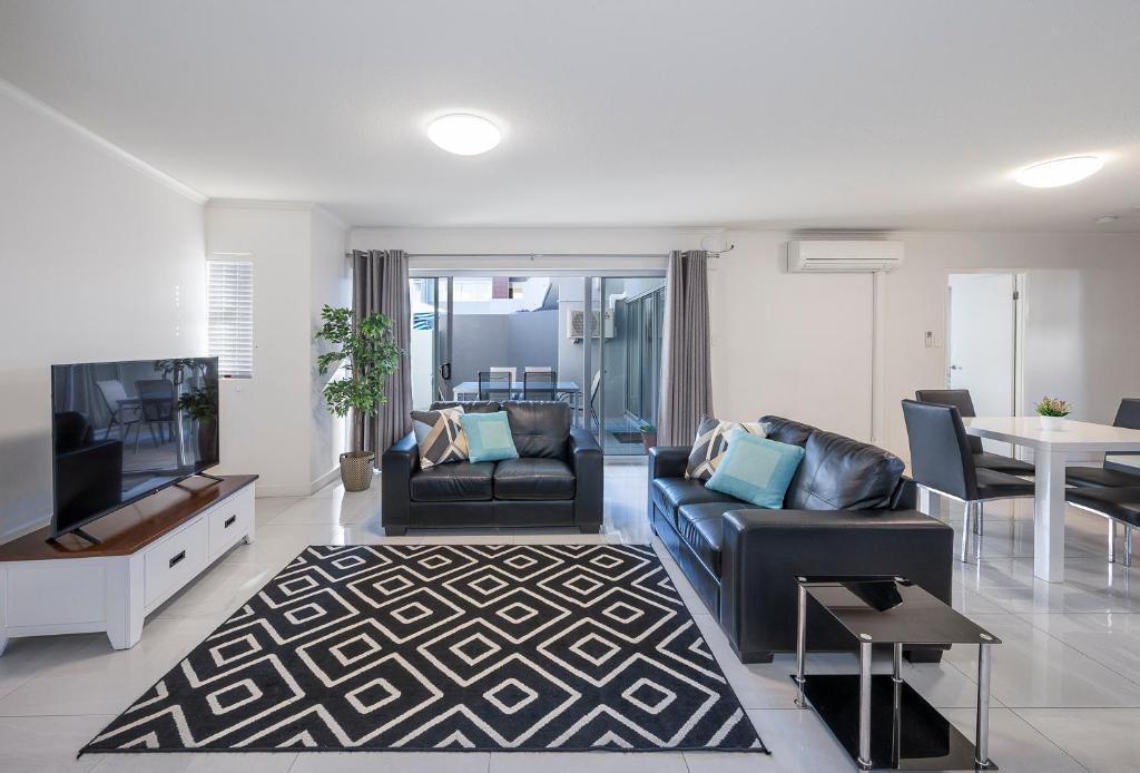 
a living room filled with furniture and a large window at FV4006 Apartments in Brisbane
