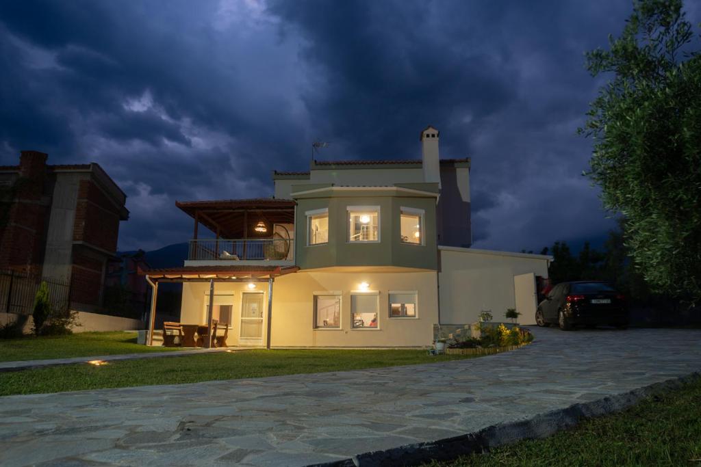 una casa con sus luces encendidas en la noche en Aelia Villa Leptokarya, en Plaka Litóchoro