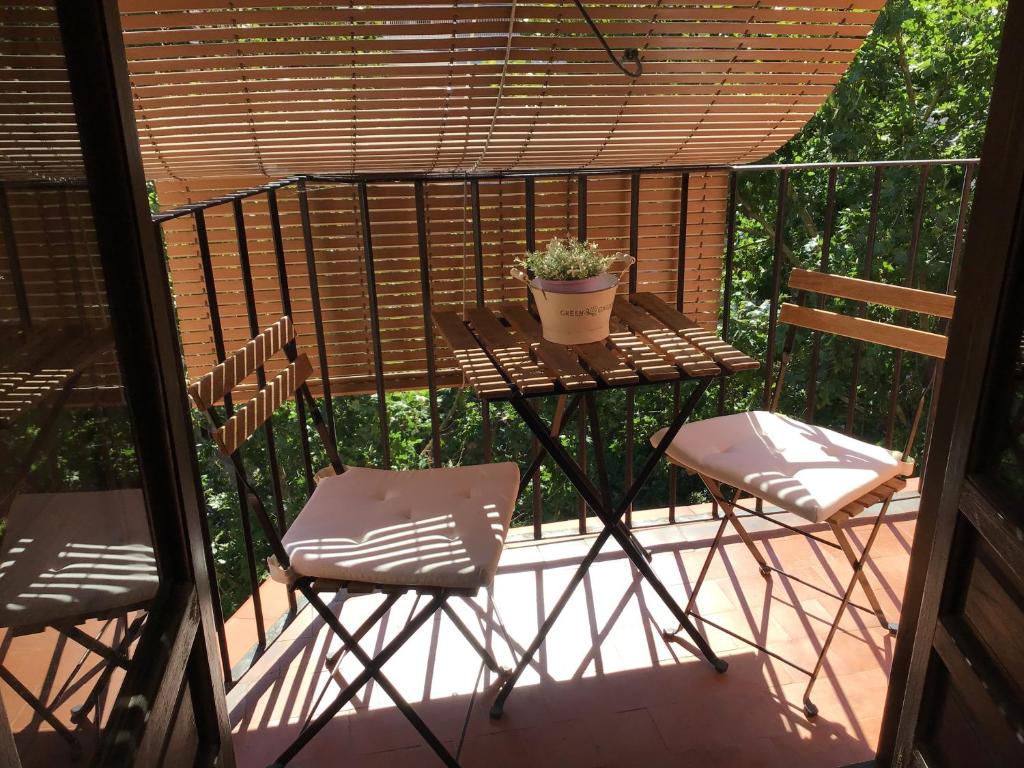 una mesa y sillas en un balcón con una maceta en Fantastico Apartamento Suite en centro de Granada, en Granada