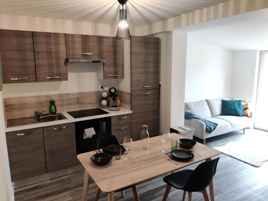 eine Küche mit einem Tisch und Stühlen im Zimmer in der Unterkunft Joli appartement avec jardin-terrasse privé in Brest