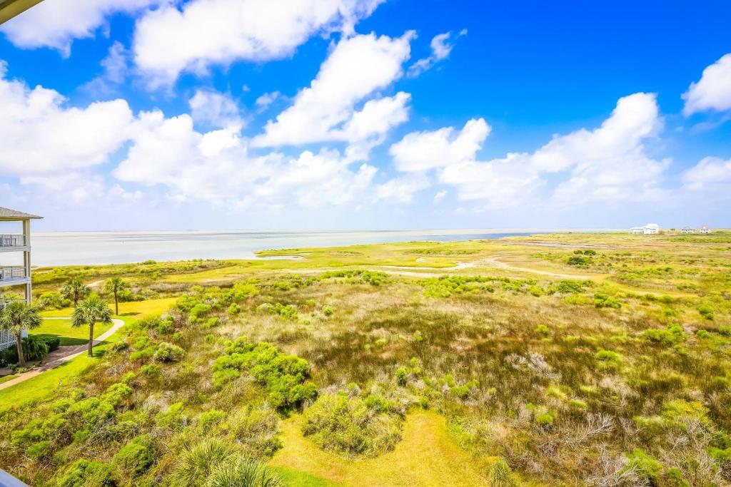 an overhead view of a golf course with the ocean in the background at Beautiful two-bedroom with bay views in the lovely Pointe West Resort in Galveston