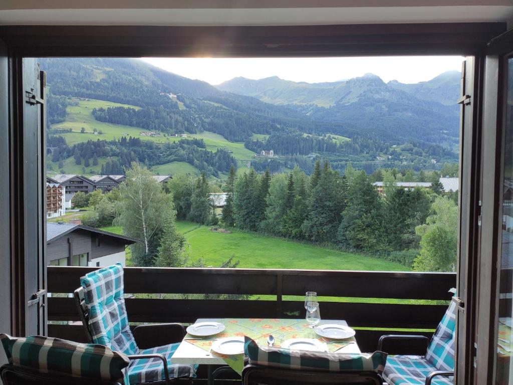 a table and chairs on a balcony with a view at Panoramawohnung Bad Hofgastein in Bad Hofgastein