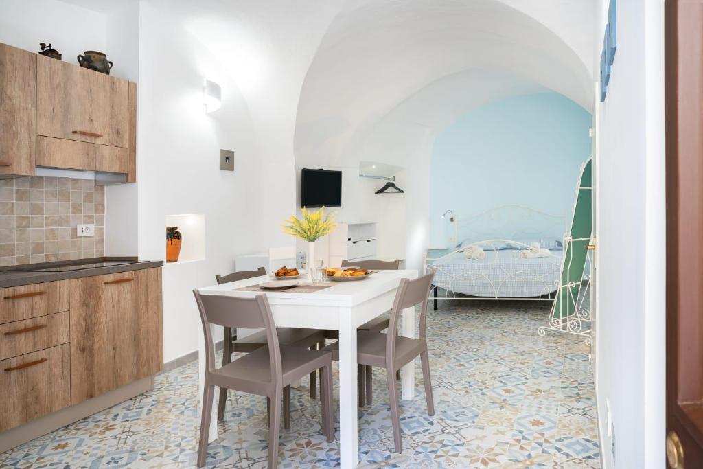 a kitchen and dining room with a table and chairs at La Finestrella in Parabita