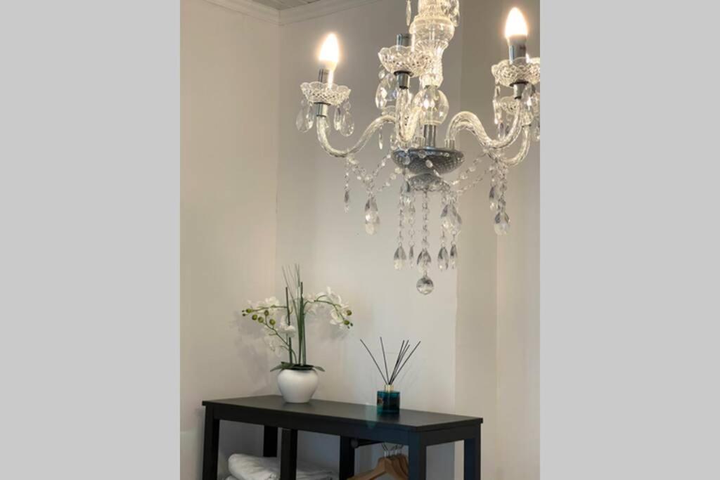 un lustre suspendu à un mur avec une table dans l'établissement cute studio rom, à Mons