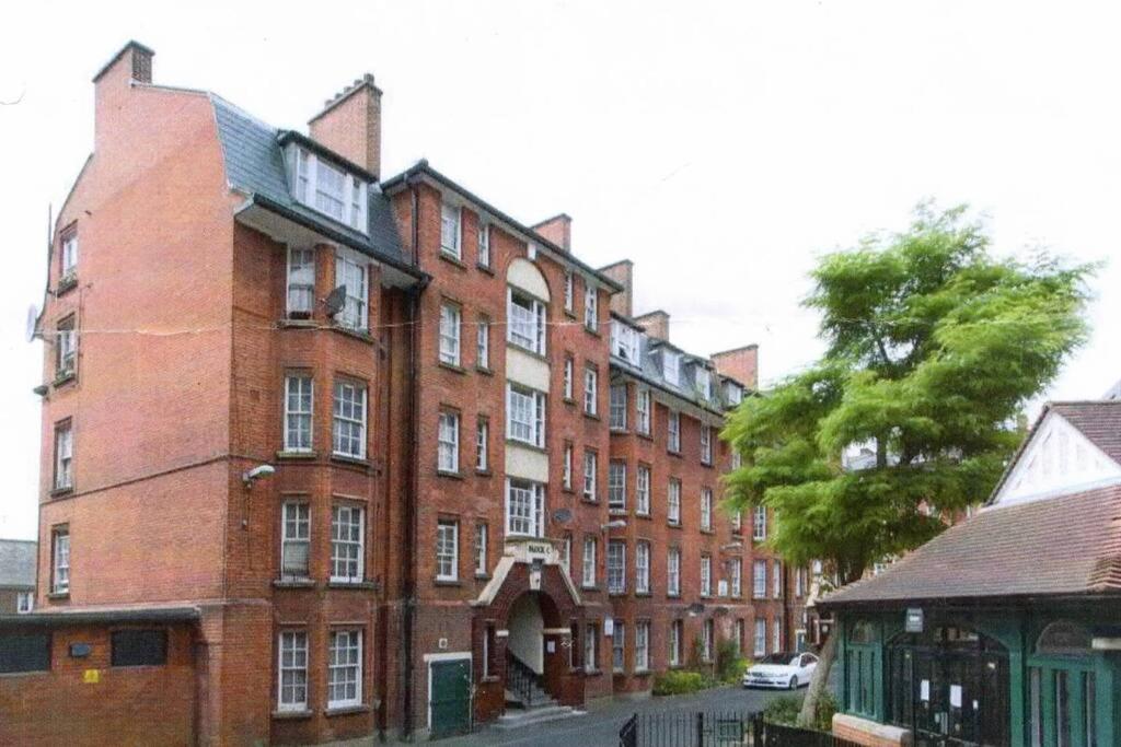 un gran edificio de ladrillo rojo en una calle de la ciudad en Central 1 BR Apartment *Zone 1* Elephant and Castle, en Londres