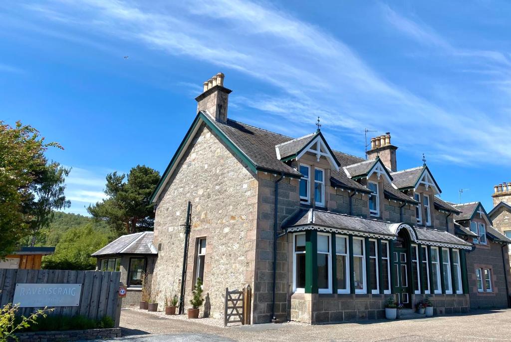 a large brick building with windows on a street at Ravenscraig Guest House in Aviemore