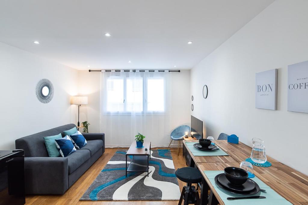 sala de estar con sofá y mesa en LE VALLES - HYPERCENTRE PARKING GRATUIT WiFi NETFLIX AMAZON PRIME, en Villeurbanne