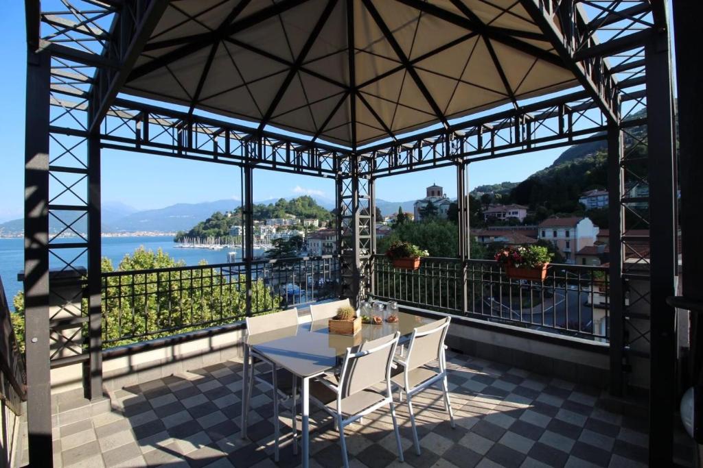 un tavolo e sedie su un balcone con vista sull'acqua di Maison Vittoria Lago Maggiore a Laveno