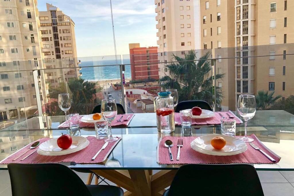 einen Tisch mit Gläsern und Teller mit Speisen auf dem Balkon in der Unterkunft MIRADOR Sea View apartment in Calpe