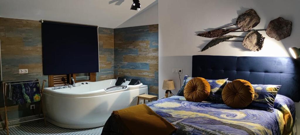 a bedroom with a tub and a bed and a bath tub at El nido de la Jabonería in Setenil