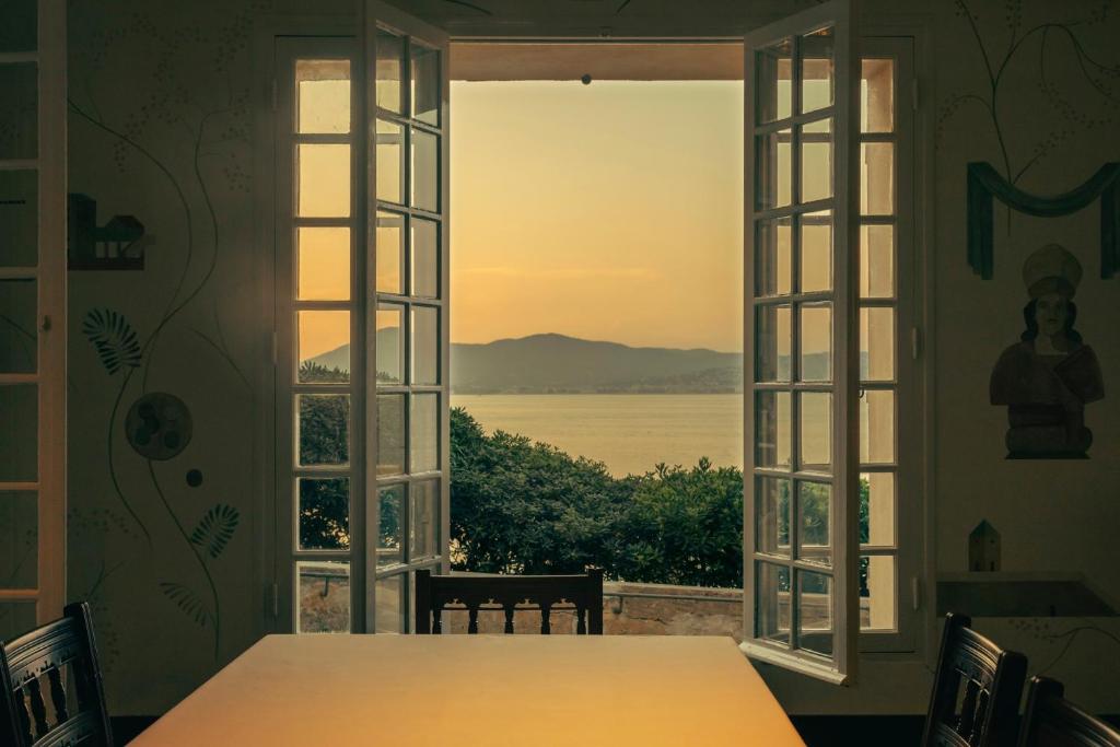 Cette chambre dispose d'une table et offre une vue sur l'eau. dans l'établissement Hotel la Ponche, à Saint-Tropez