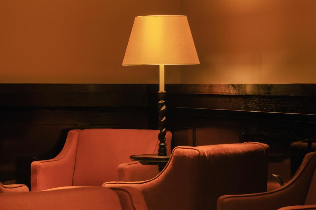 a lamp sitting next to two chairs and a table at Hotel la Ponche in Saint-Tropez