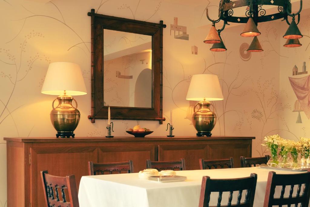 a dining room with a table with two lamps and a mirror at Hotel la Ponche in Saint-Tropez