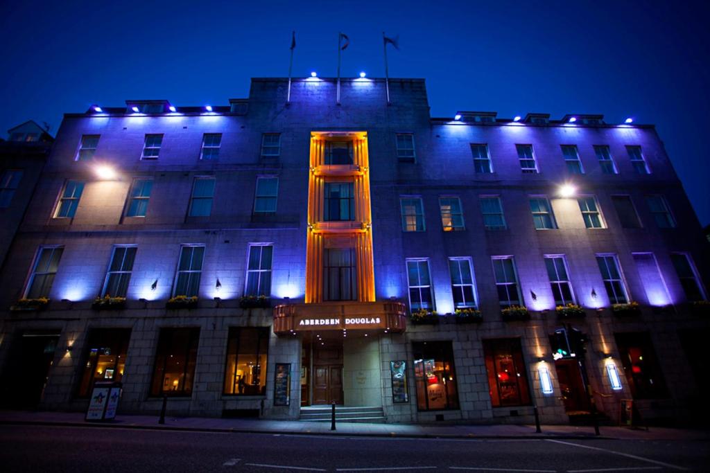 un bâtiment éclairé la nuit en bleu et orange dans l'établissement Aberdeen Douglas Hotel, à Aberdeen